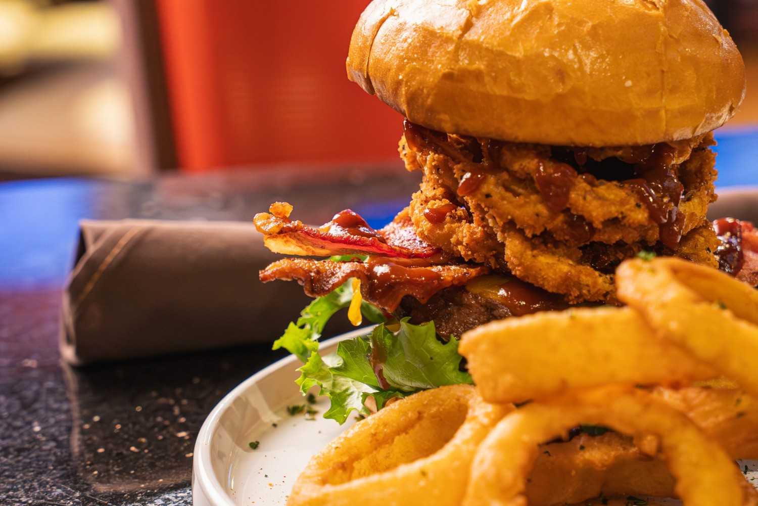 Crispy fried chicken bacon burger with onion rings served at restaurant in Yreka, CA