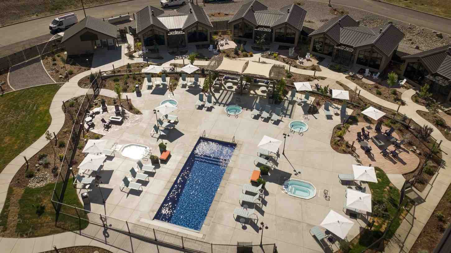 Aerial view of apartment pool area with lounge chairs and hot tubs in Yreka, CA