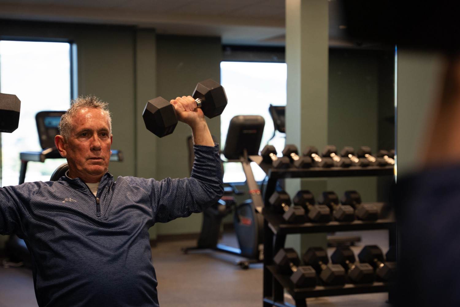 Person exercising with dumbbells in Rain Rock Casino fitness center
